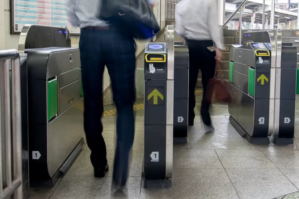 People entering modern fare gates in subway station.